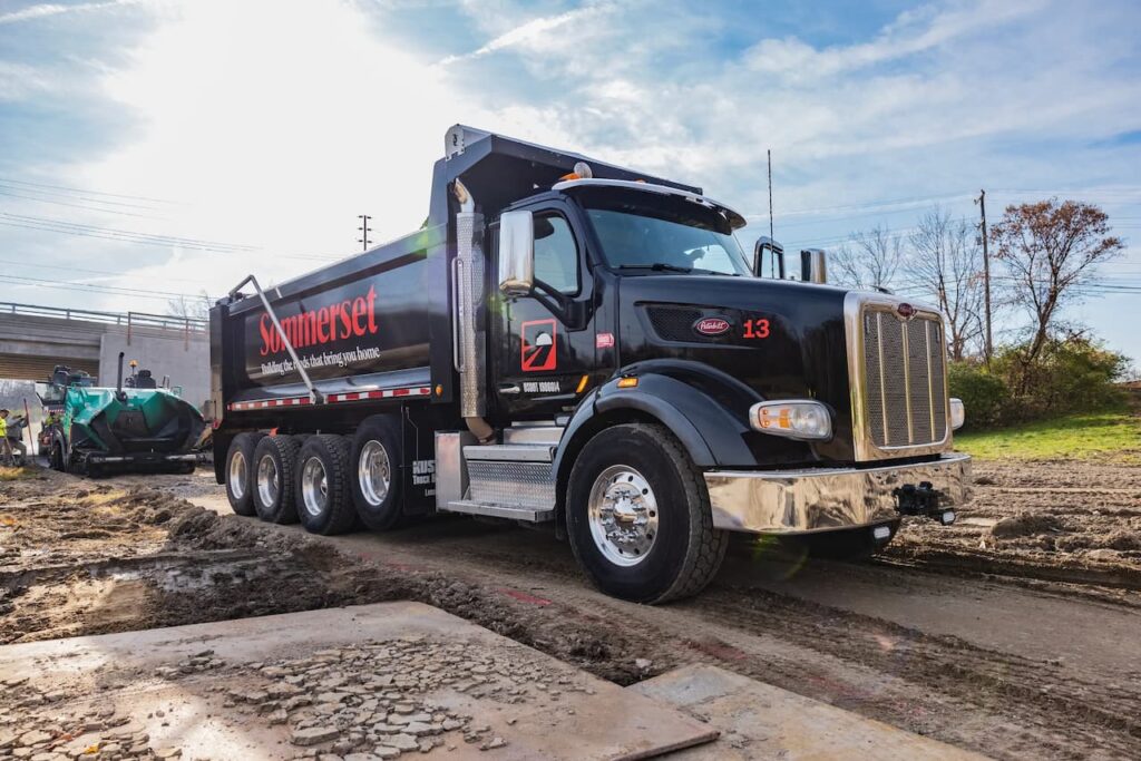 A Sommerset Paving black truck parked on a construction site outside